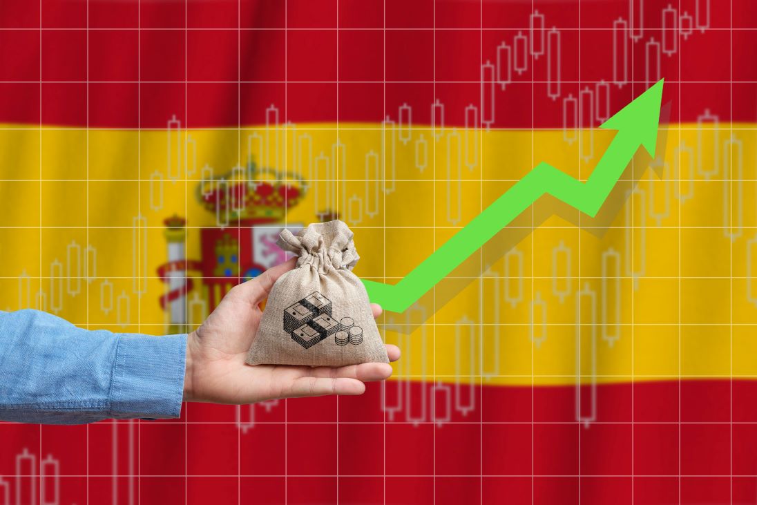 Vlag van Spanje als achtergrond en een hand met daarin een zakje met waarschijnlijk munten daarin