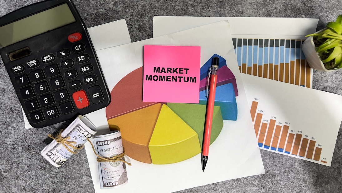 Tafel met een papier met daarop een taartgrafiek, verder een rekenmachientje, potlood, en bankbiljetten in een rolletje met elastiek