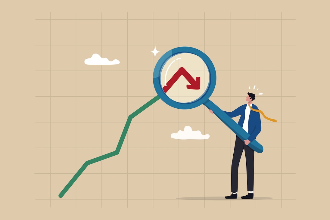 Man met groot vergrootglas kijkende naar dalende koersgrafieklijn