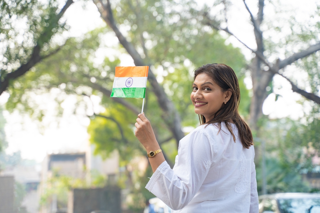 Jonge vrouw met vlaggetje van India in haar hand
