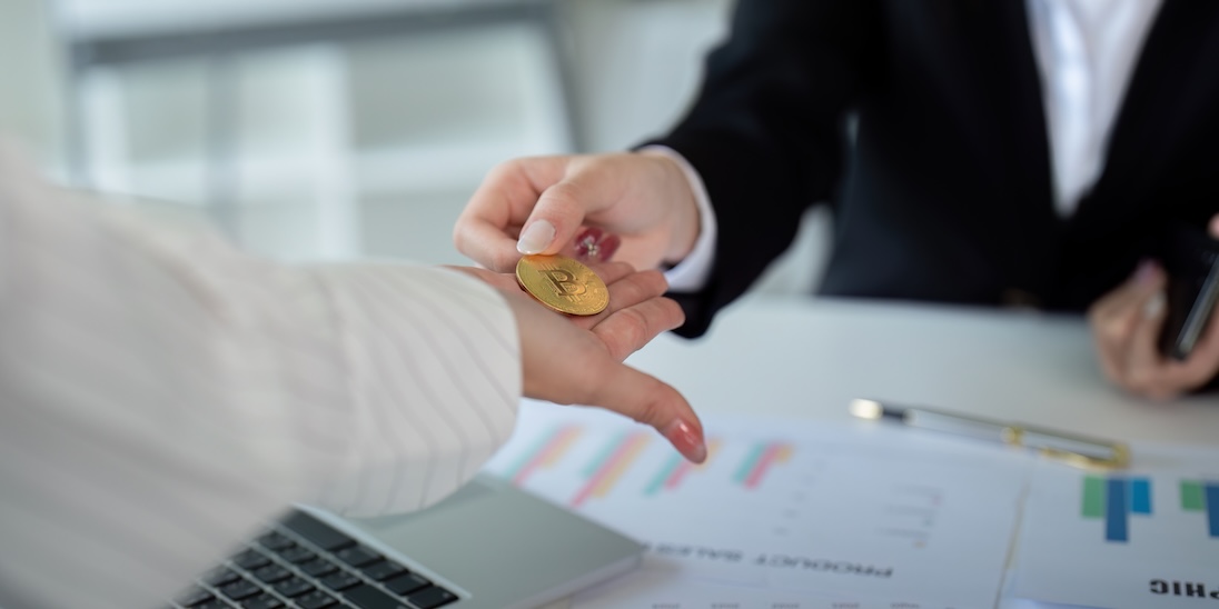 Man geeft dame een bitcoin munt