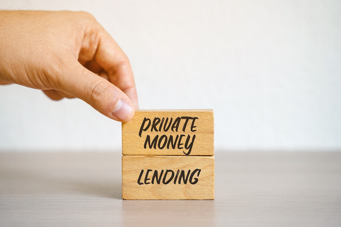 Hand die twee blokjes met tekst PRIVATE MONEY LENDING op elkaar stapelt
